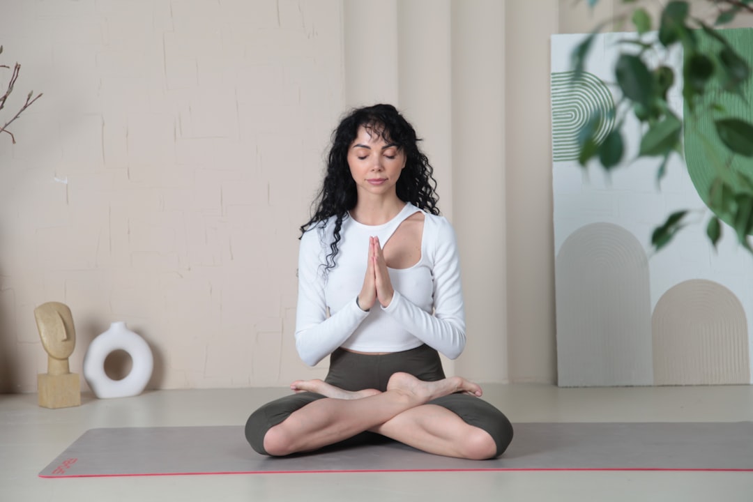 a-woman-sitting-in-a-yoga-position-with-her-eyes-closed-4c3ehixiovi